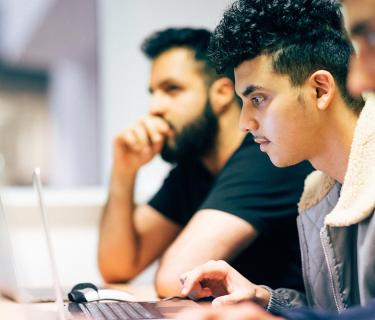 Three students using laptops