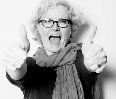 Black and white photo of Pauline Roche showing a double thumbs up