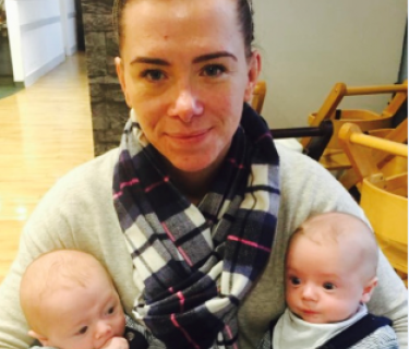Woman sitting and holding twin babies