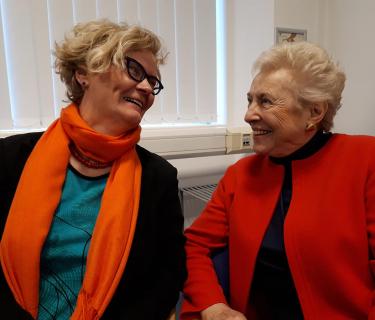 two women looking at each other and smiling