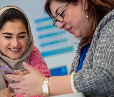 Two women looking at an iphone together