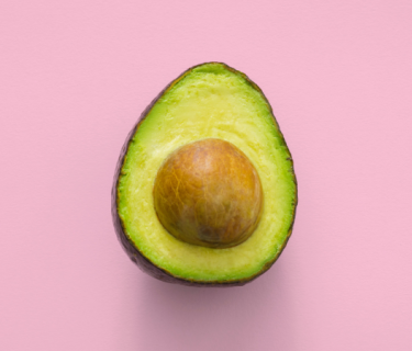 Half an avocado on a pink background