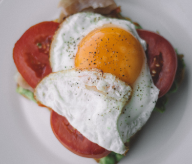 Plate with bread, lettuce, tomato, and an egg on it