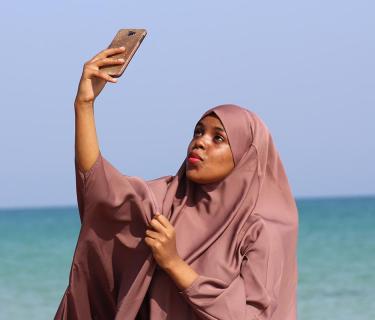 Woman taking a selfie and wearing traditional Islamic clothing