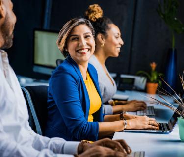 Colleagues smiling at their desks at work