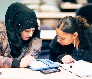 Two students looking at Ipad in classroom