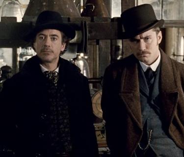 Sherlock Holmes and Dr Watson stand in a room wearing bowler hats