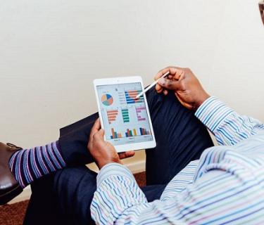 Man with leg crossed using Ipad