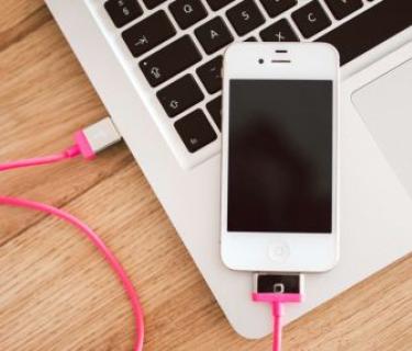 A cellphone plugged into a laptop