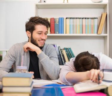 Woman with head down on table with man sitting beside her