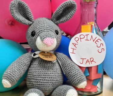 Stuffed bunny beside a jar that says happiness jar