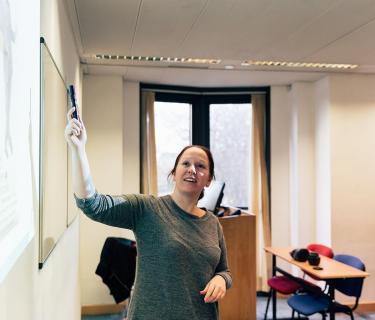 Teacher pointing at a chalkboard