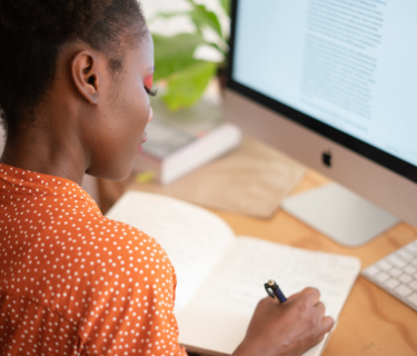 woman in orange shirt at desk