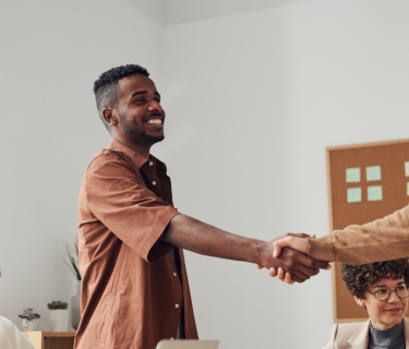 two people shaking hands in office