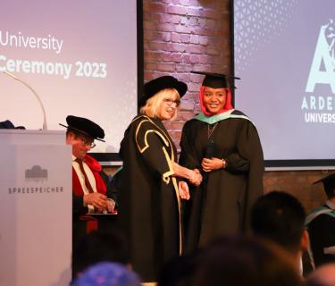a student receives their diploma on stage