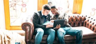 Arden University students studying on sofa in a cafe
