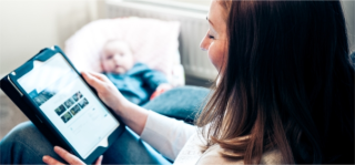 Arden University student studying with baby looking on