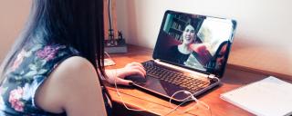 woman looking at laptop with headphones in 