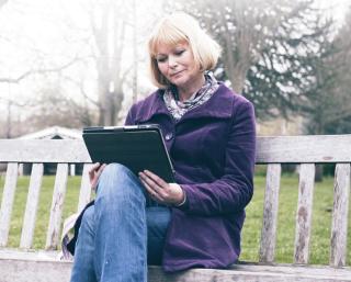 Arden University student studying on bench via Distance Learning